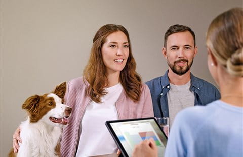 Femme et homme avec chien en consultation de prévoyance Femme et homme avec chien en consultation de prévoyance
