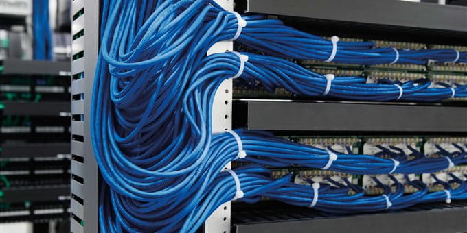 Blaues Kabel, ordentlich an einem Rack befestigt, mit weiteren Geräten im Hintergrund. Blaues Kabel, ordentlich an einem Rack befestigt, mit weiteren Geräten im Hintergrund.