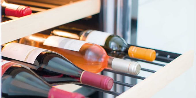 A wine rack drawer with several bottles of wine in various colors and labels. A wine rack drawer with several bottles of wine in various colors and labels.