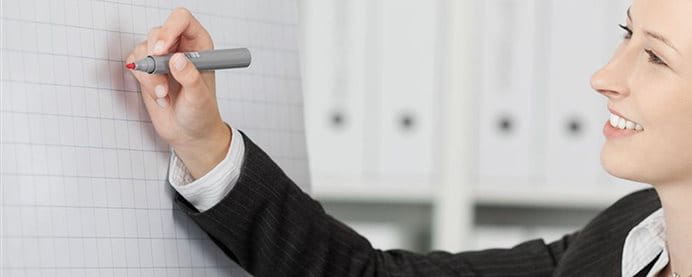 Zwei Frauen schreiben auf eine weisse Tafel. Zwei Frauen schreiben auf eine weisse Tafel.