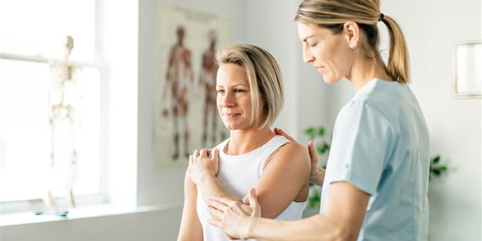 Une médecin examine l’épaule d’une patiente dans un cabinet médical. Une médecin examine l’épaule d’une patiente dans un cabinet médical.