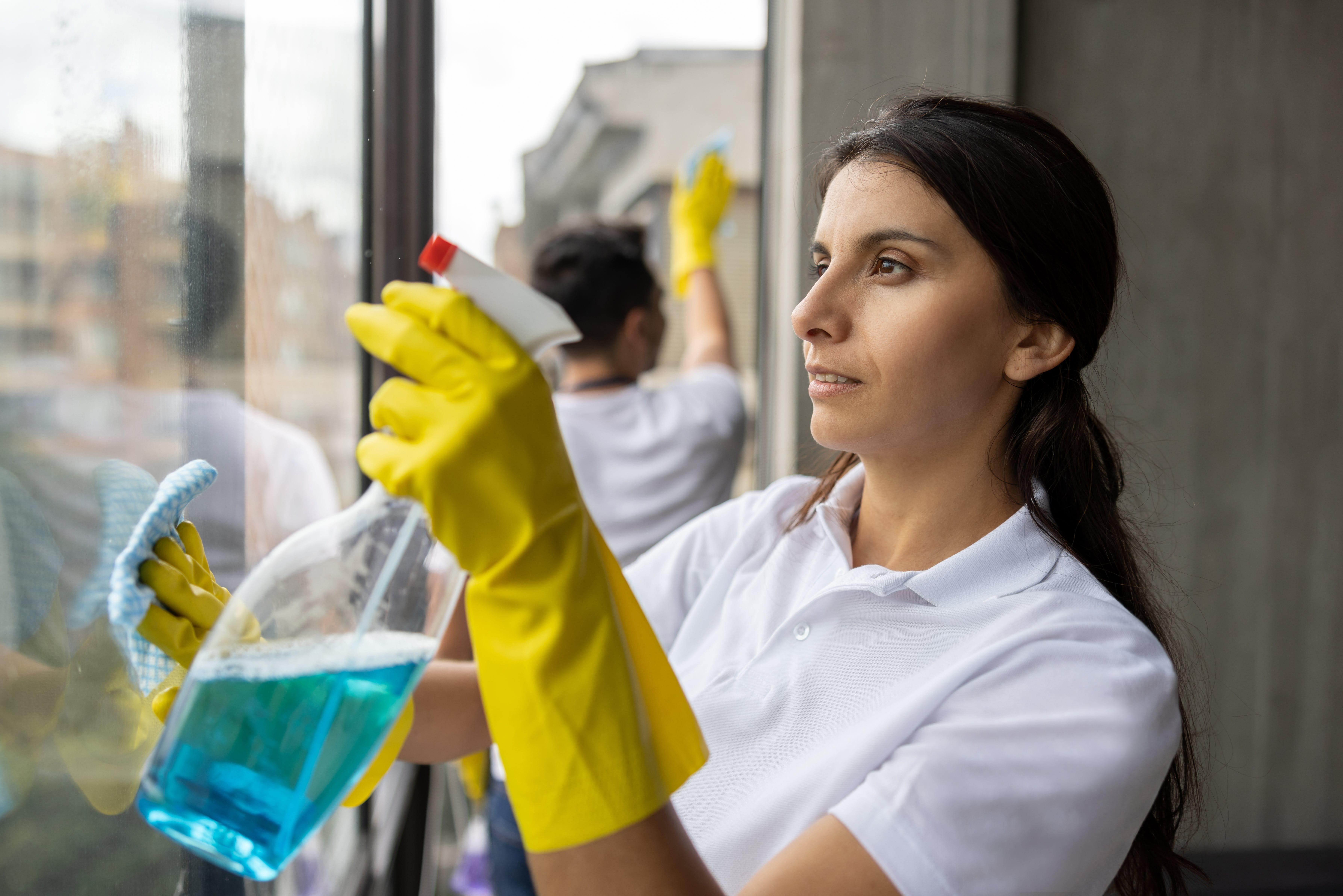 A woman is cleaning a window