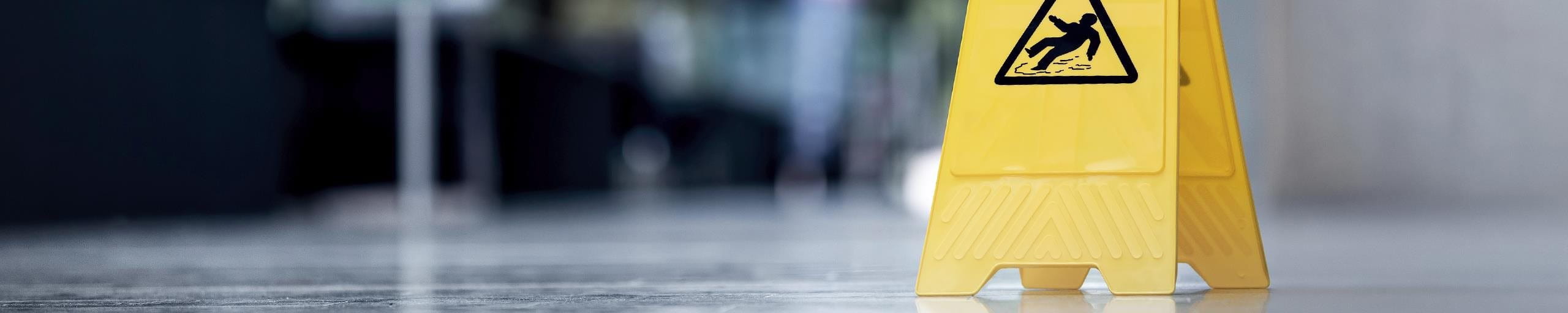 Eine gelbe Gefahrentafel steht auf dem Boden.