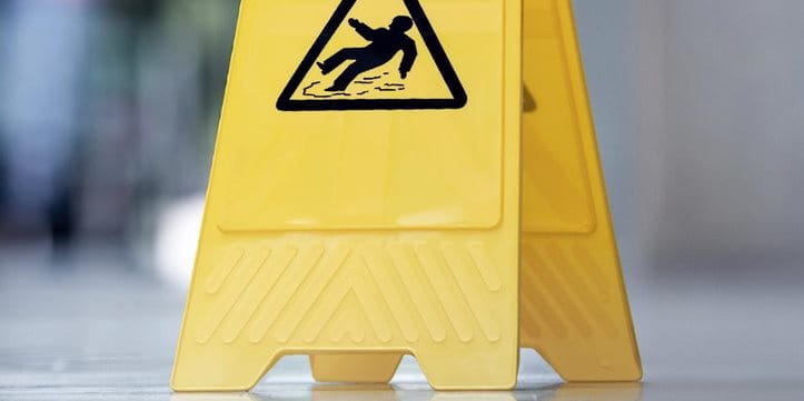Un panneau indicateur de danger de glissade est posé sur le sol. Un panneau indicateur de danger de glissade est posé sur le sol.