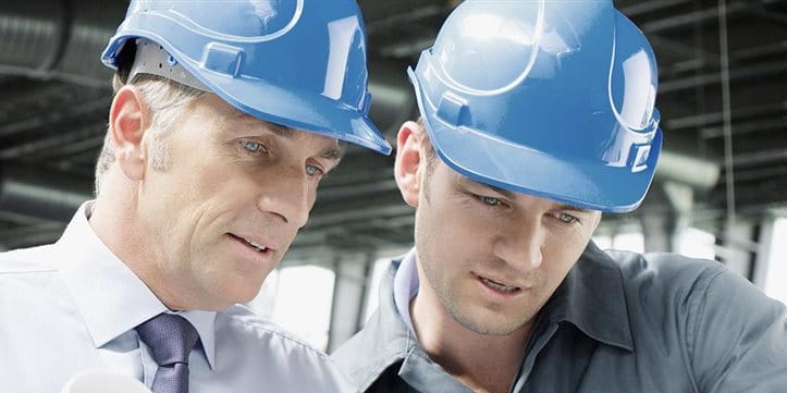 Due uomini con casco di protezione che discutano. Due uomini con casco di protezione che discutano.