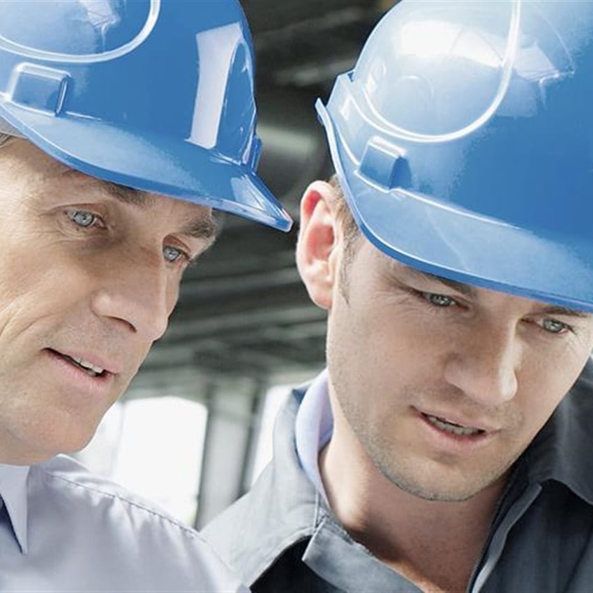 Deux hommes avec des casques de protection discutent sur un chantier. Deux hommes avec des casques de protection discutent sur un chantier.
