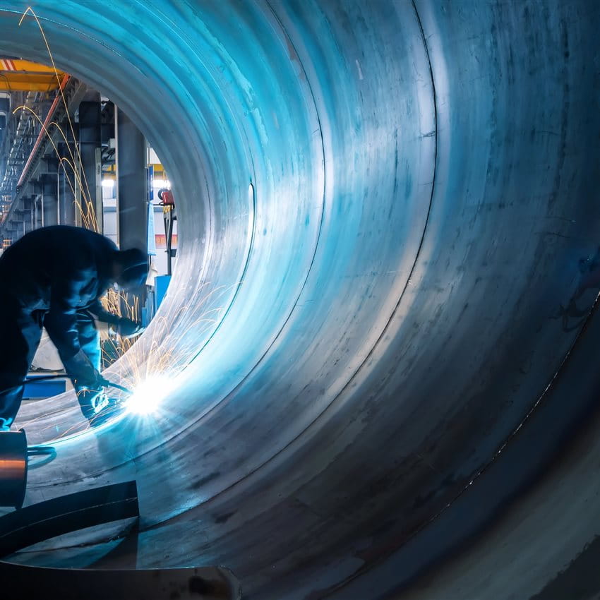 A welder is working inside a large pipe, with sparks flying. A welder is working inside a large pipe, with sparks flying.