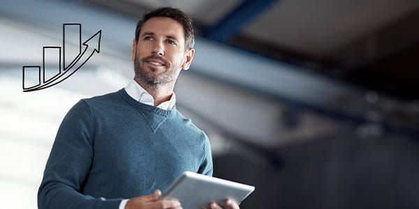 Un homme regarde par une fenêtre sur laquelle est dessiné un bâtiment d’entreprise, et pense à sa prévoyance professionnelle.