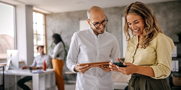 Un homme et une femme regardent un téléphone et rient