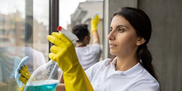 Une femme nettoie une fenêtre