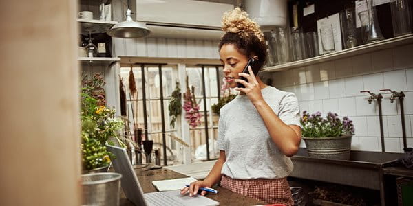 Une femme est devant l'ordinateur portable et téléphone