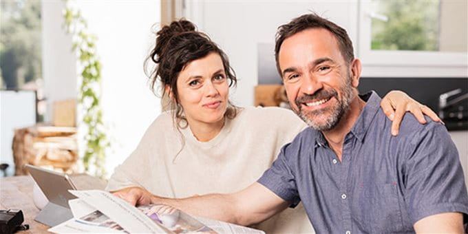 Donna e uomo che leggono il giornale al tavolo Donna e uomo che leggono il giornale al tavolo