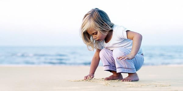 Une fillette joue dans un champ.