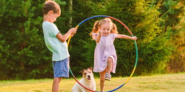 Des enfants qui jouent dehors avec un chien.