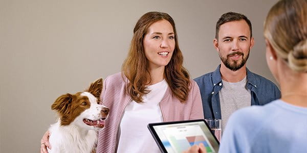 Femme et homme avec chien en consultation de prévoyance
