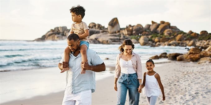 Coppia di famiglie a passeggio sulla spiaggia di sabbia con 2 bambini Coppia di famiglie a passeggio sulla spiaggia di sabbia con 2 bambini