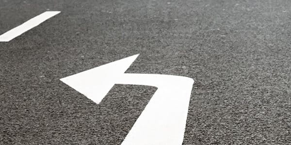 Deux flèches de direction sur une route.