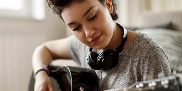 Un adolescent joue de sa précieuse guitare