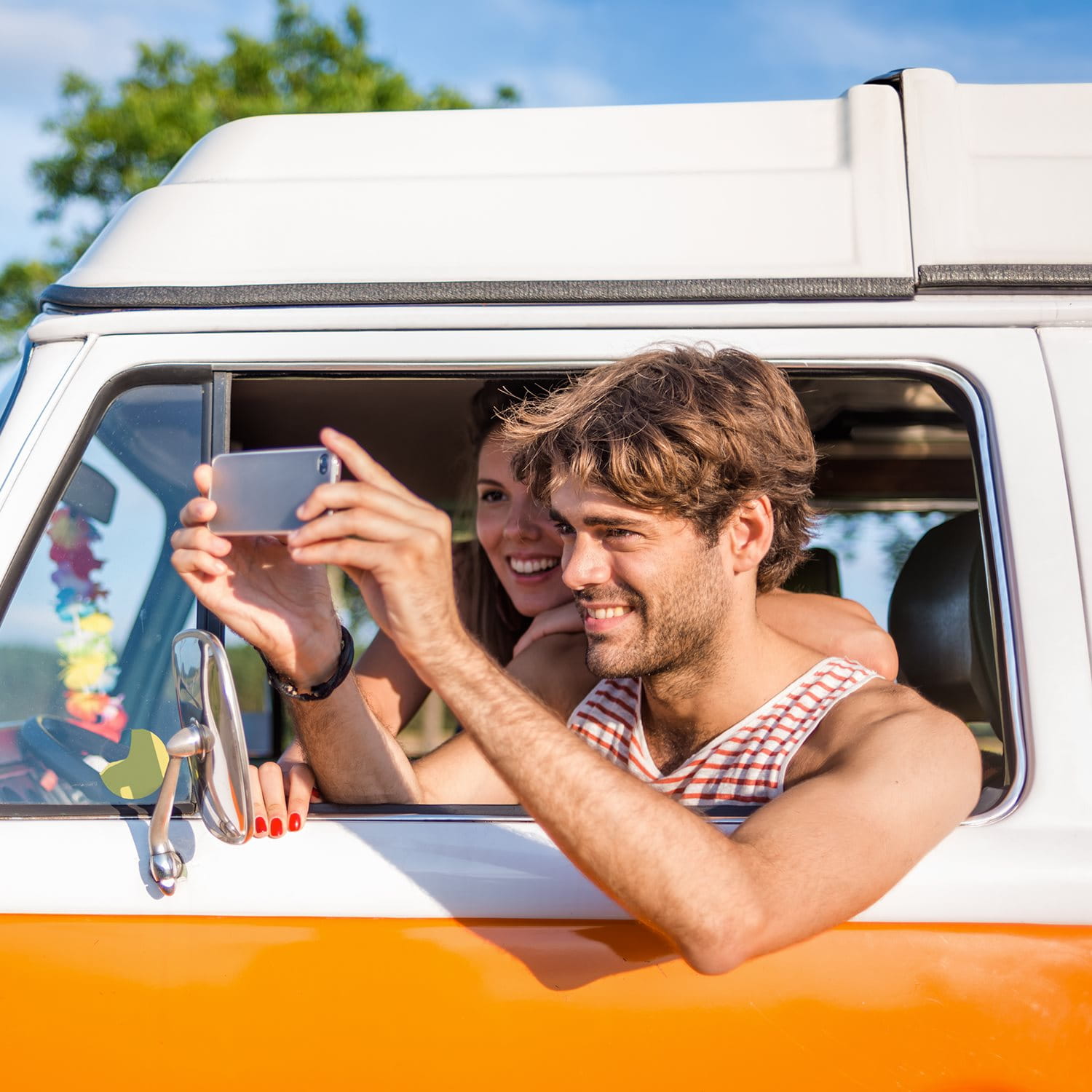 Eine Person macht ein Foto aus einem orangefarbenen Fahrzeugfenster.