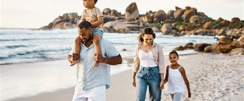 Familienpaar läuft auf Sandstrand mit 2 Kindern Familienpaar läuft auf Sandstrand mit 2 Kindern