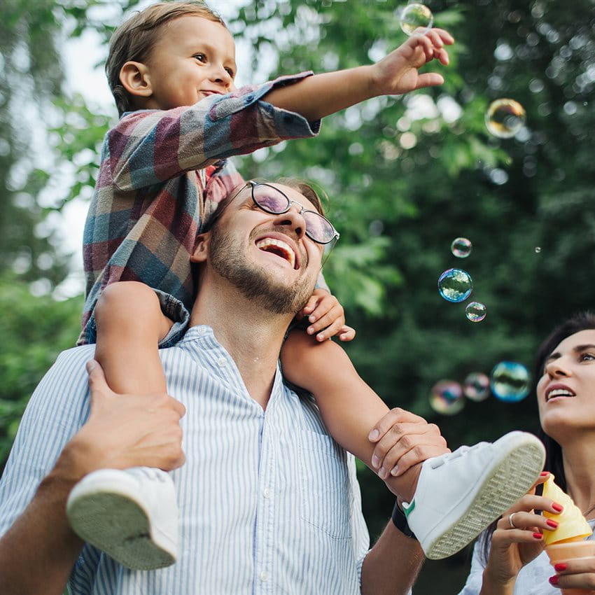 A family is playing together outdoors, blowing soap bubbles. A family is playing together outdoors, blowing soap bubbles.