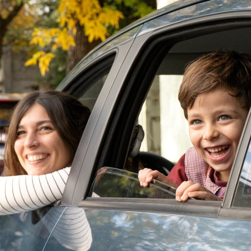 Two children sitting in a car, looking relaxed out of the open window. Two children sitting in a car, looking relaxed out of the open window.
