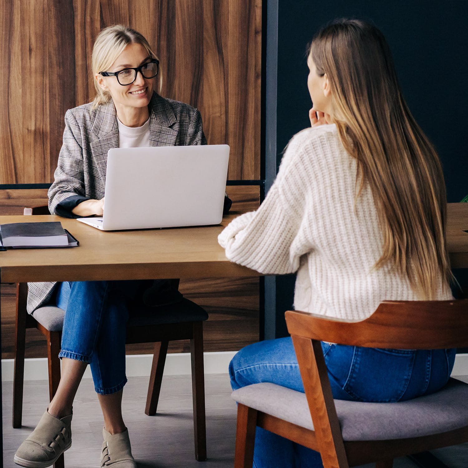 Deux femmes assises à une table, l’une avec un ordinateur portable, lors d’un entretien de conseil