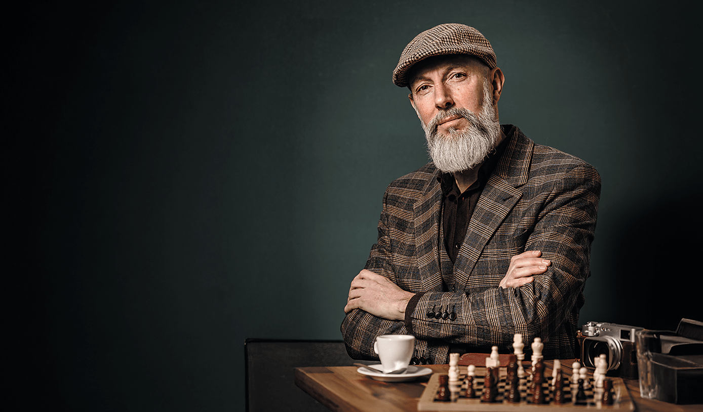 Well-dressed, elderly man with a chessboard