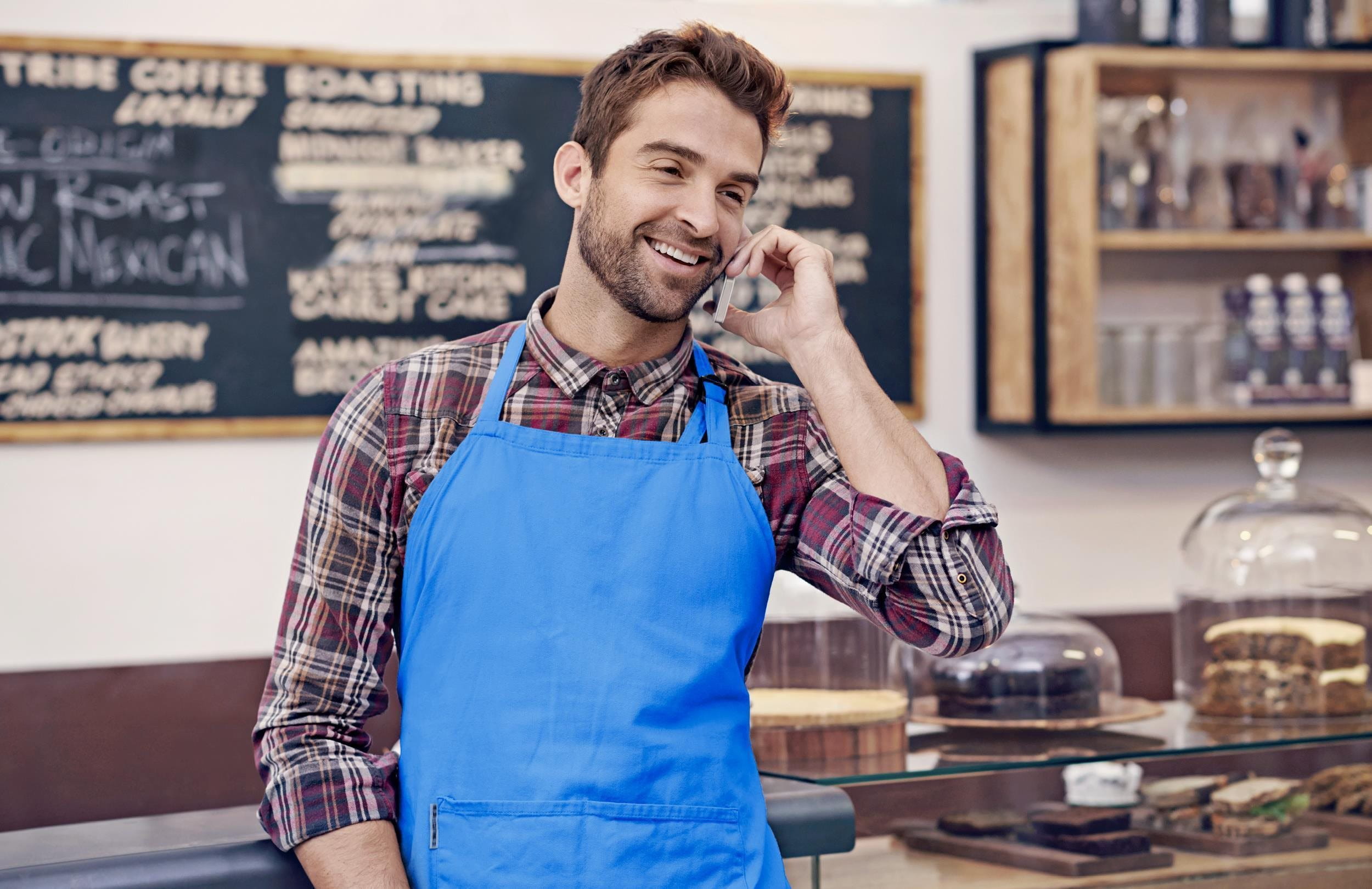 Telefonando uomo in grembiule blu
