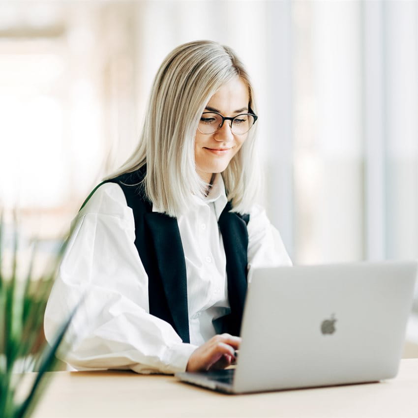 Une professionnelle travaille sur un ordinateur portable dans un espace de bureau moderne et lumineux. Une professionnelle travaille sur un ordinateur portable dans un espace de bureau moderne et lumineux.