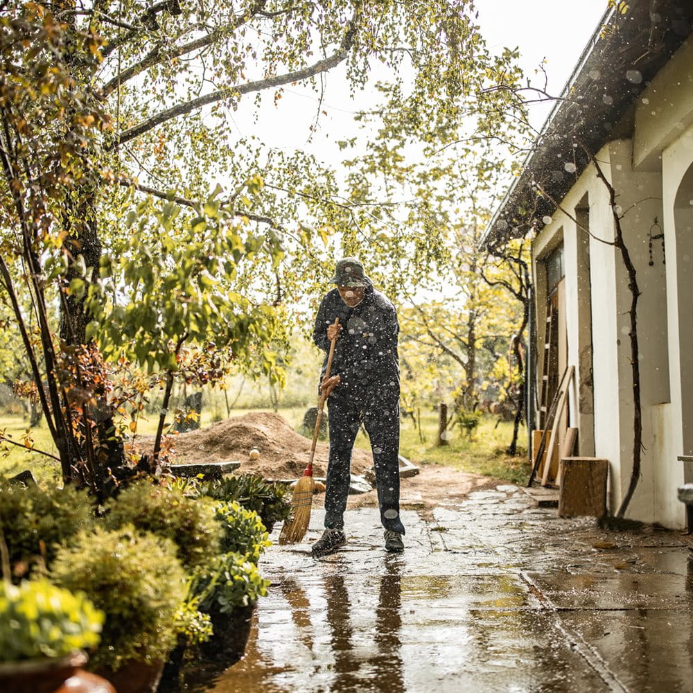 Man wiping wet terrace after continuous rain