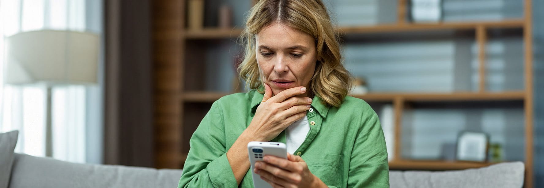 Frau schaut besorgt auf ihr Smartphone
