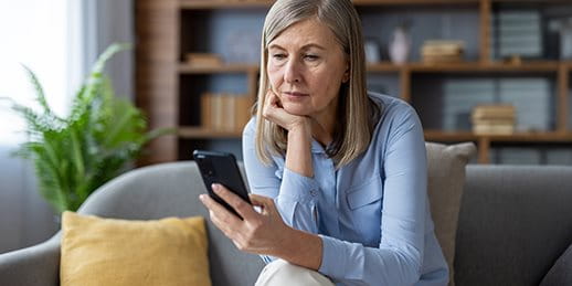 Frau schaut auf ihr Mobiltelefon