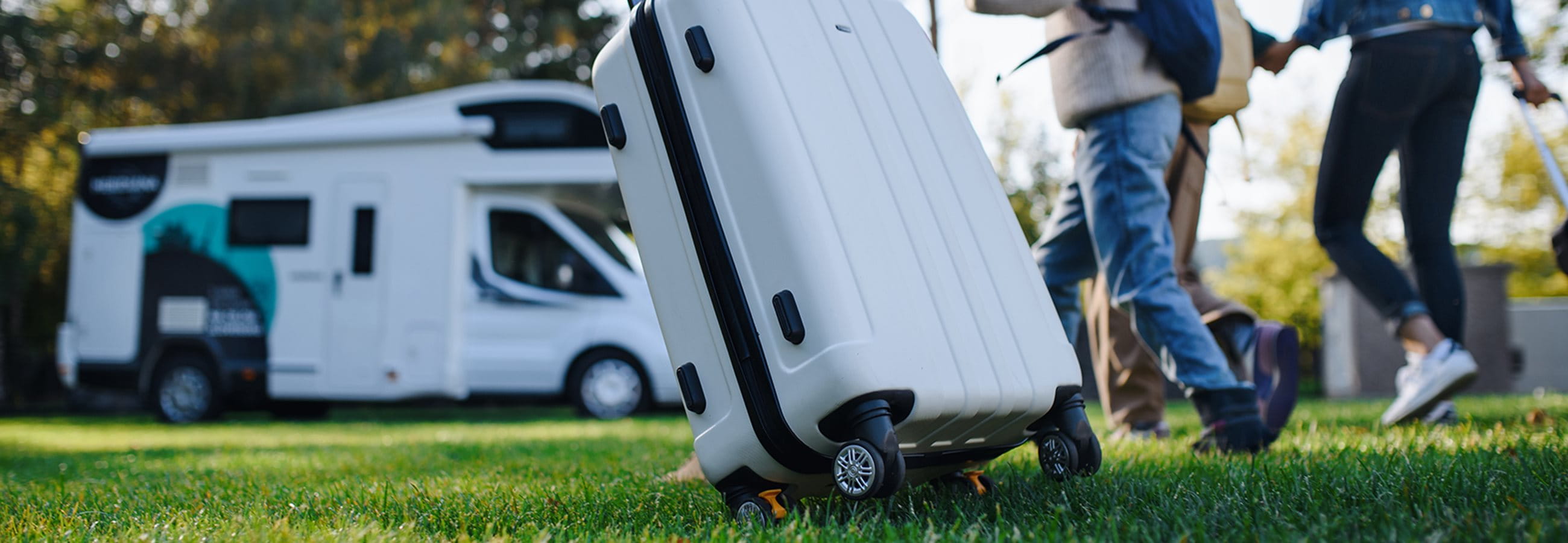 Familie mit Koffer auf Campingplatz