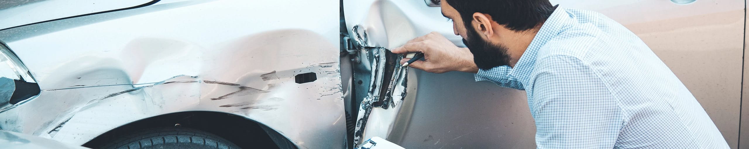 Man examines damage to the vehicle