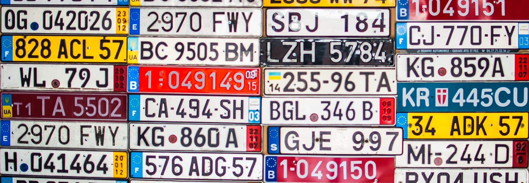 Viele verschiedene Nummernschilder an einer Fläche angebracht