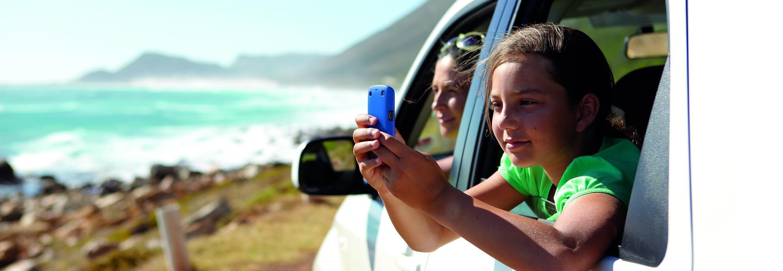 Enfant avec téléphone portable dans la voiture