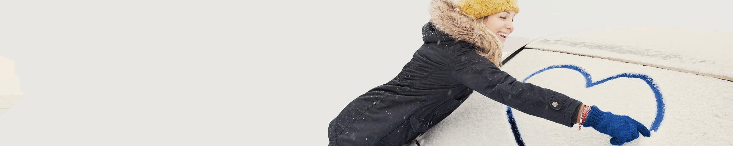 La donna disegna un cuore sulla finestra dell'auto