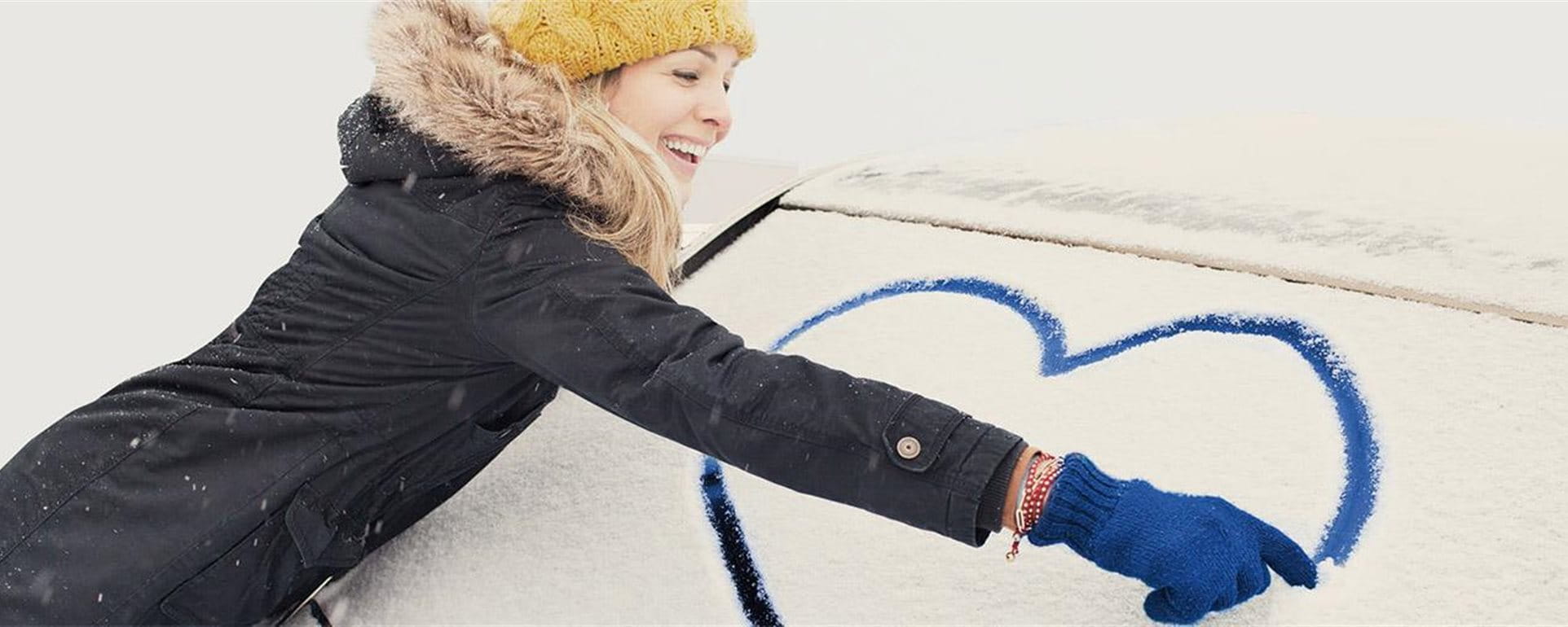 Femme peint coeur sur la fenêtre de voiture Femme peint coeur sur la fenêtre de voiture