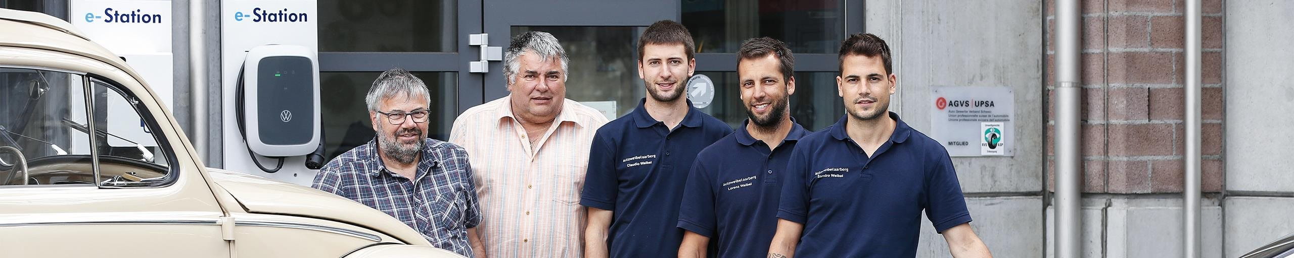 Owners of Weibel in front of their garage