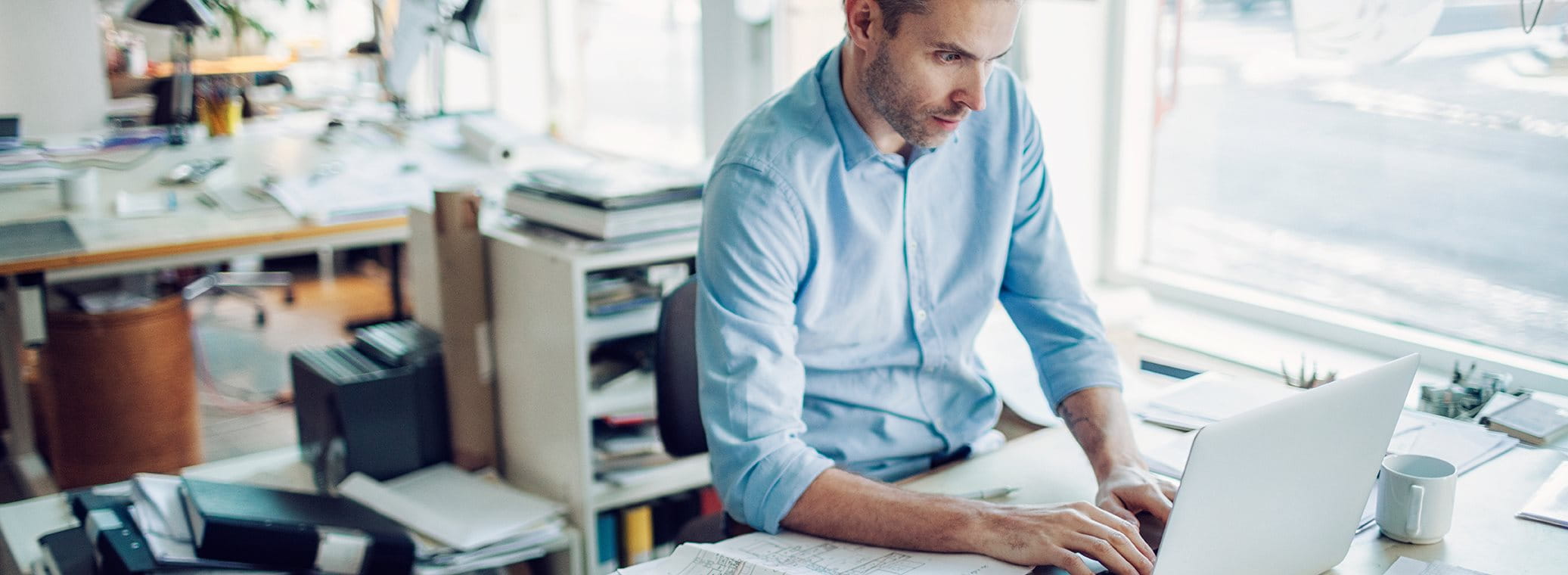 Ein Mann sitzt in einem Büro an seinem Arbeitstisch