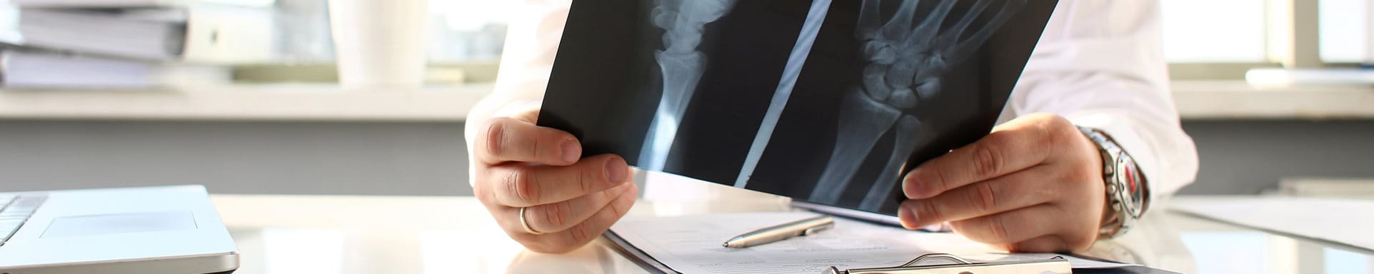 Un médecin s'assied à la table et regarde une image radiographique. Un médecin s'assied à la table et regarde une image radiographique.