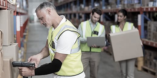 Un logisticien avec une manchette Smart Wearable scanne un colis Un logisticien avec une manchette Smart Wearable scanne un colis