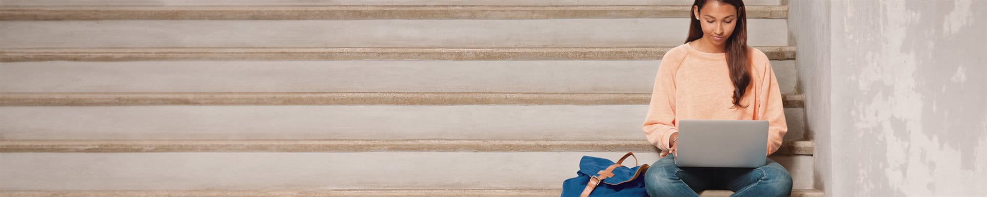 Junge Frau sitzt auf einer Treppe am Laptop Junge Frau sitzt auf einer Treppe am Laptop