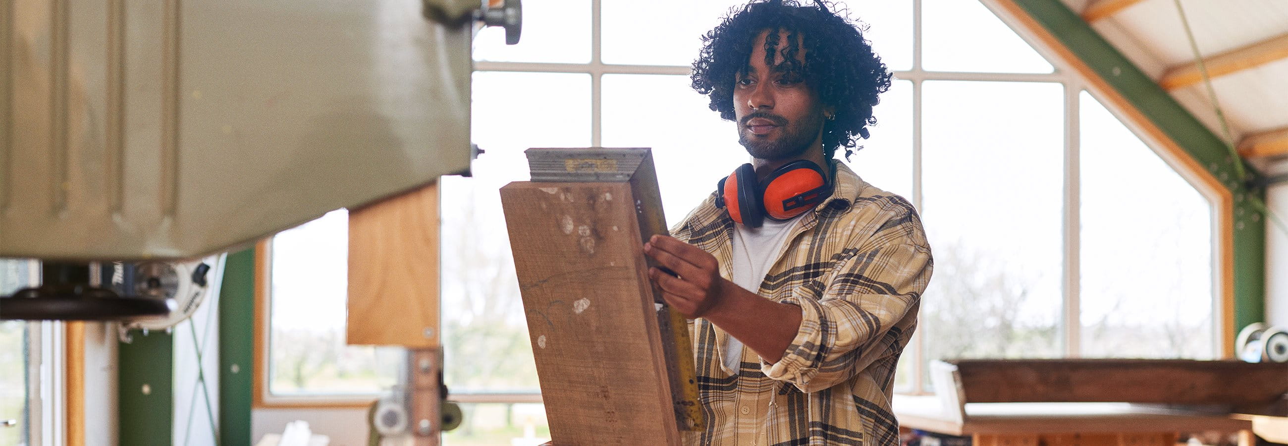 L'homme travaille dans un atelier de menuiserie  L'homme travaille dans un atelier de menuiserie