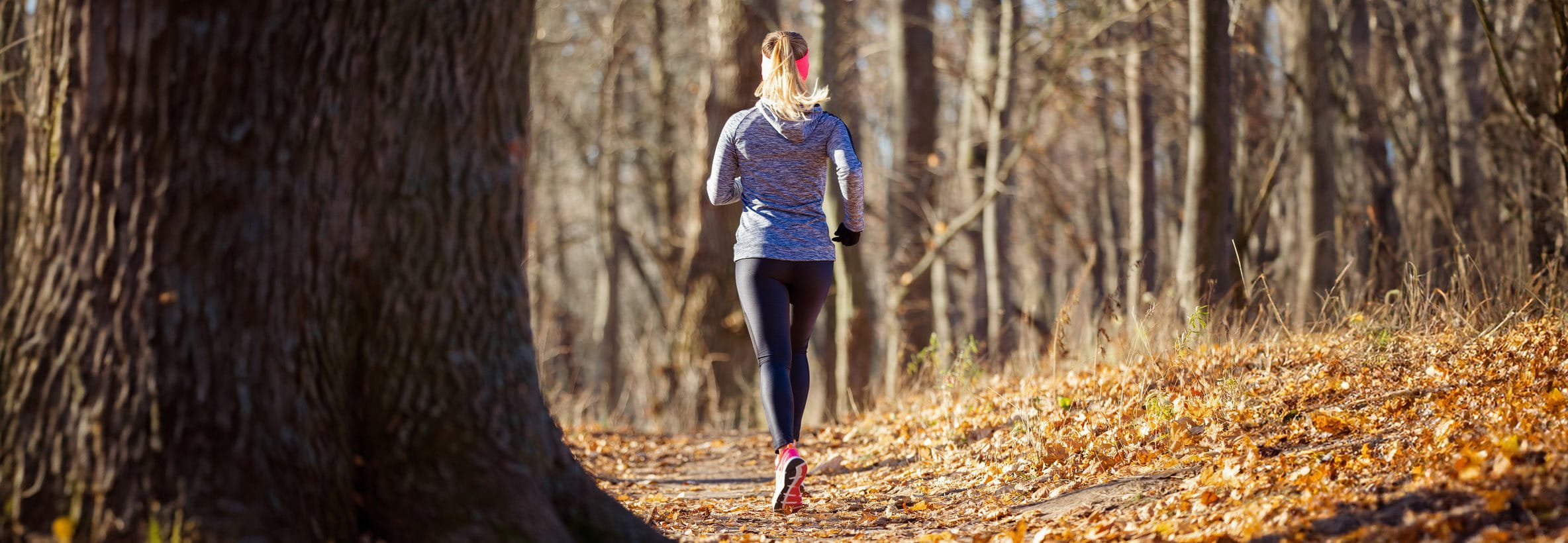 donna che fa jogging nella foresta