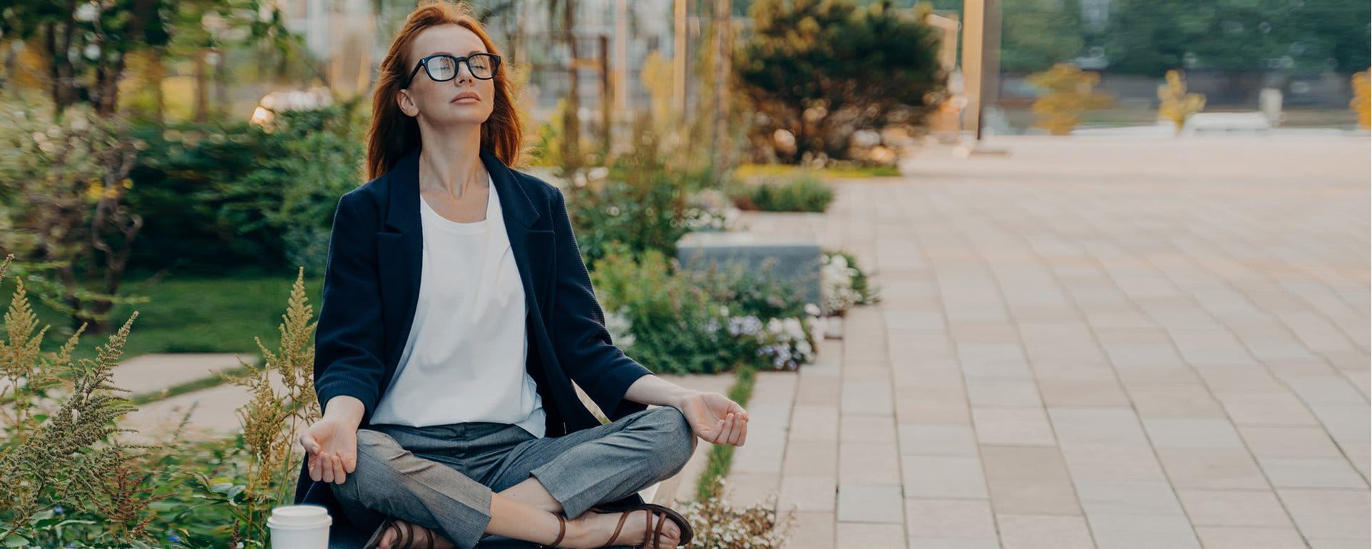 La femme s'assied en parc et fait le yoga La femme s'assied en parc et fait le yoga
