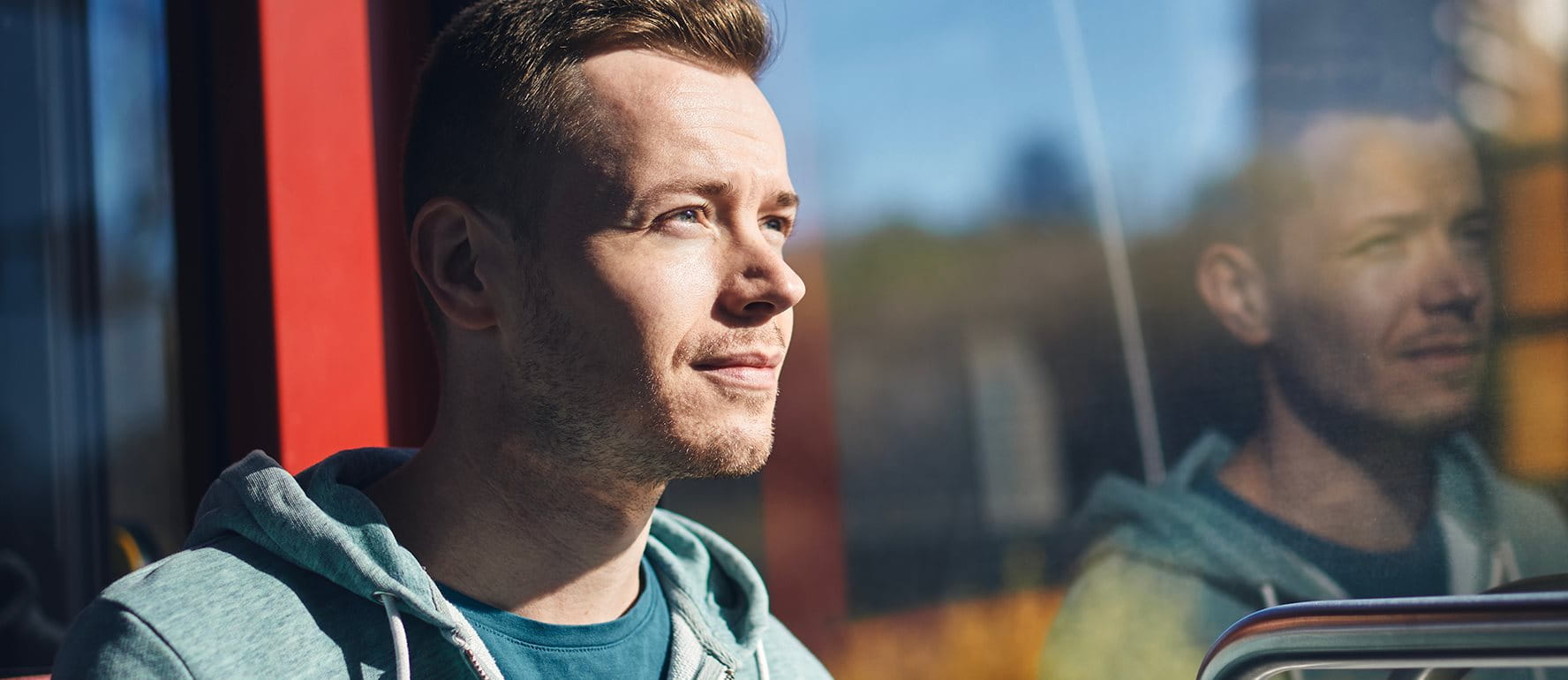 Personne assise dans les transports publics, regardant pensivement par la fenêtre. Personne assise dans les transports publics, regardant pensivement par la fenêtre.