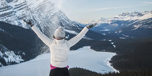 Frau steht auf einem Berg im Schnee