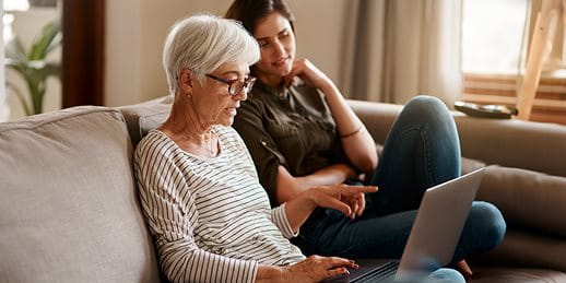 Mutter und Tocher schauen gemeinsam in ein Laptop